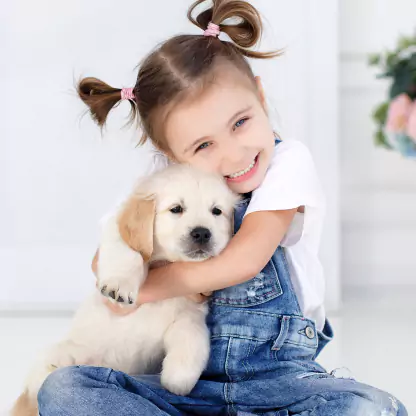 Young girl hugging a happy, healthy puppy at a trusted pet store in Kendall, Florida